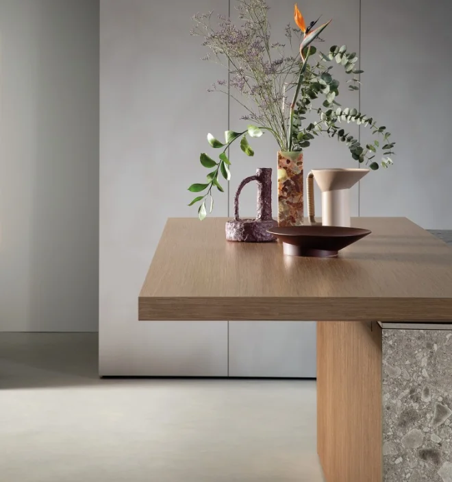 Wood kitchen island with stone side panel and floral arrangement