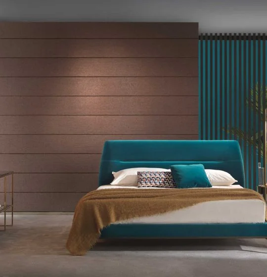 Teal upholstered bed against a wood-panelled wall
