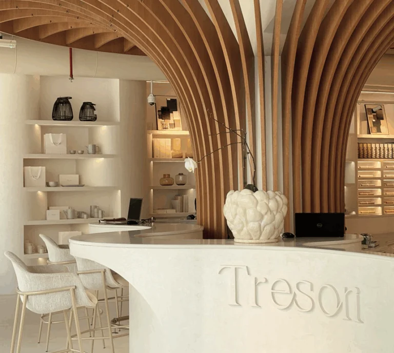Curved stone reception counter with the Tresori name beneath sculptural timber arches.