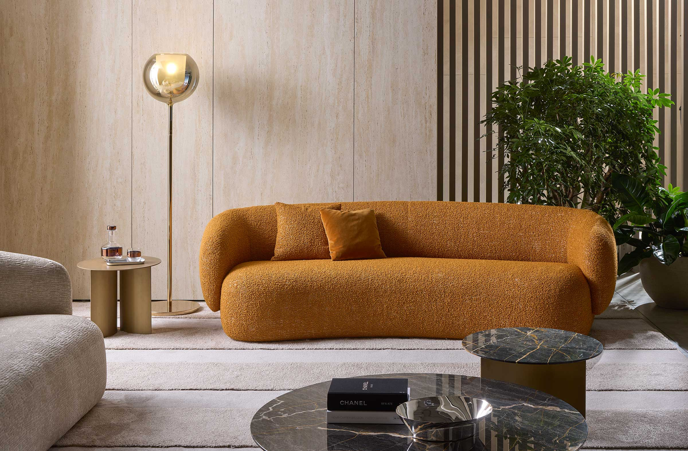 A Milanese living room with travertine walls, sculptural seating and warm afternoon light