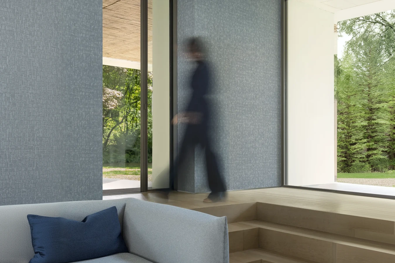 Architectural material wall beside seating and an indoor tree