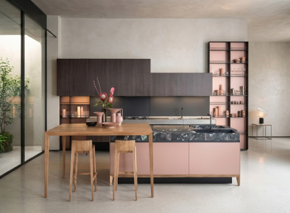 Modern kitchen with a pink island, dark stone worktop and wooden dining table
