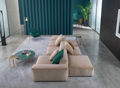 Beige modular sofa and green coffee tables in a living room with a tall teal wall