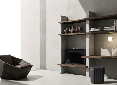 Dark sculptural chair and open shelving against pale stone walls