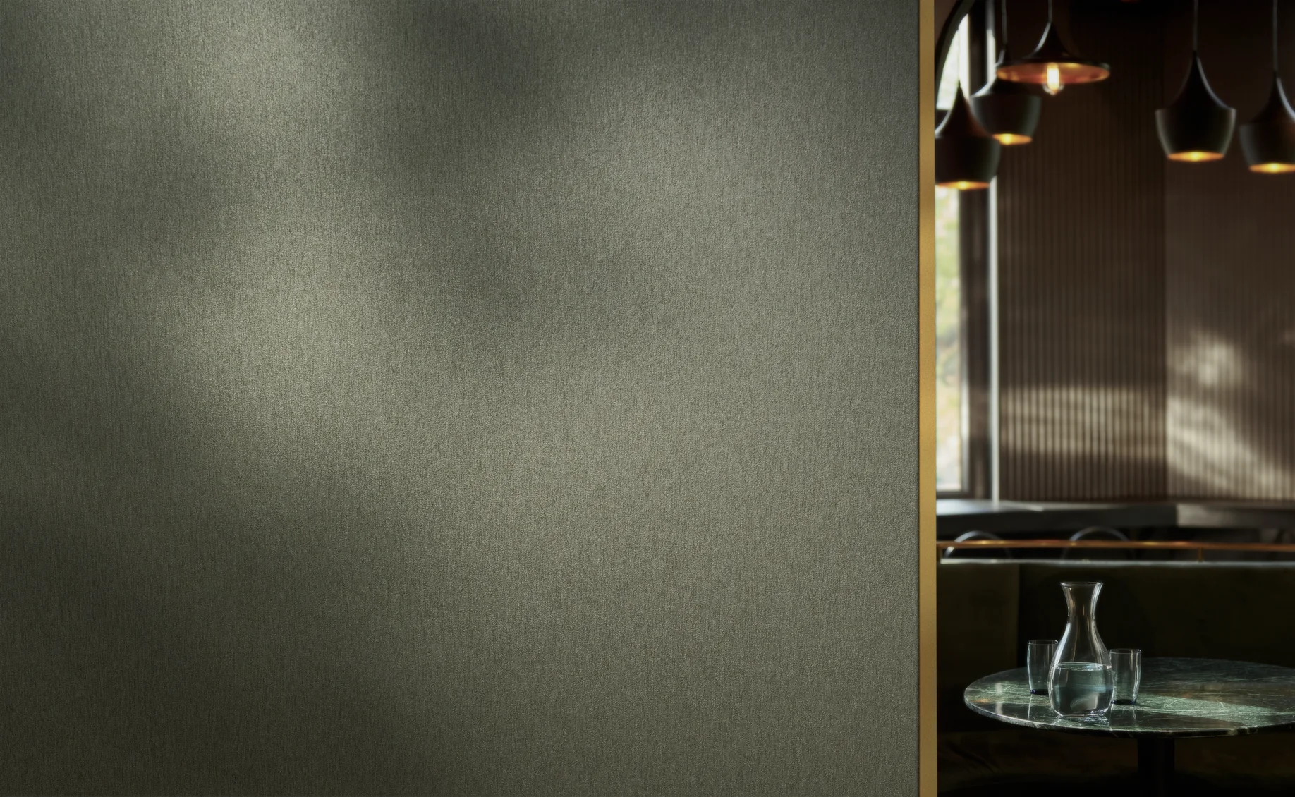 Textured Vescom Stellar wallcovering beside a softly lit dining area with pendant lights.
